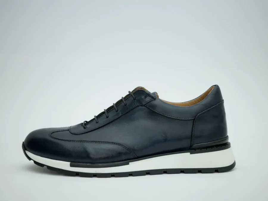 Handcrafted in Italy, this lace-up model showcases a sleek navy calfskin upper with a smooth, polished finish that highlights the purity of the design. The minimalist construction is elevated by precise stitching and a streamlined silhouette, giving the shoe a modern yet timeless character. 