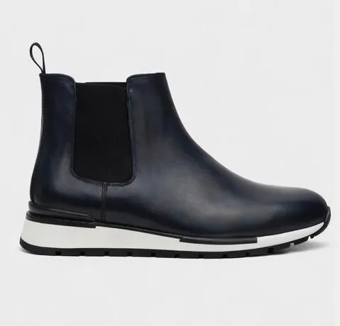 This refined Chelsea boot blends classic elegance with contemporary comfort. Crafted from smooth navy leather, it features a streamlined ankle-high silhouette with elastic side panels for easy slip-on wear. The rounded toe and minimalist stitching create a polished look, while the lightweight contrasting sole adds a modern, sporty edge.